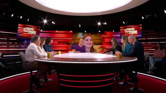 Illustratief studiobeeld van De Tafel van Tine: ronde gesprekstafel en rood decor